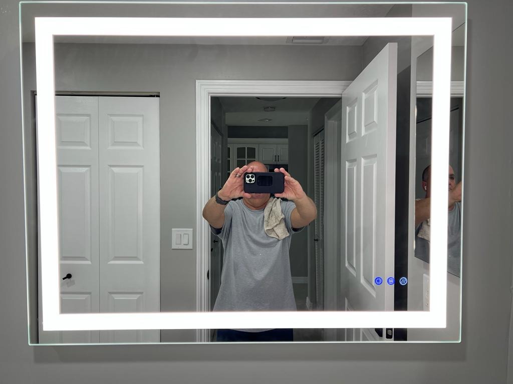Backlit LED bathroom mirror mounted on a grey wall - Handyman Group SFL