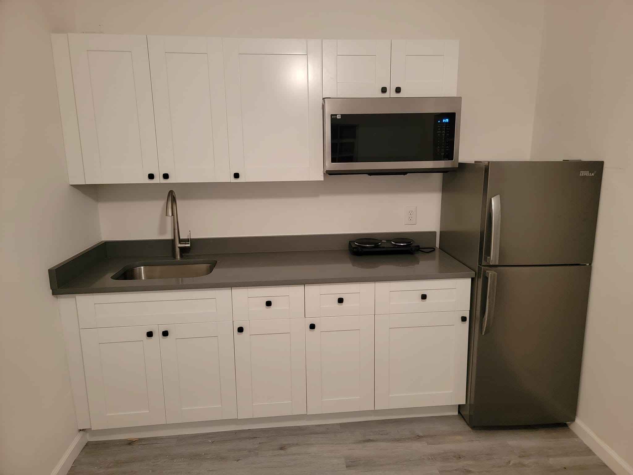 Finished Kitchenette Remodel with White Cabinets and Stainless Appliances - Handyman Group SFL