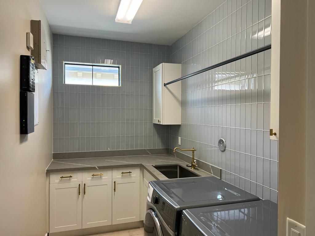 Finished Laundry Room Remodel with Gray Tile and White Cabinetry - Handyman Group SFL