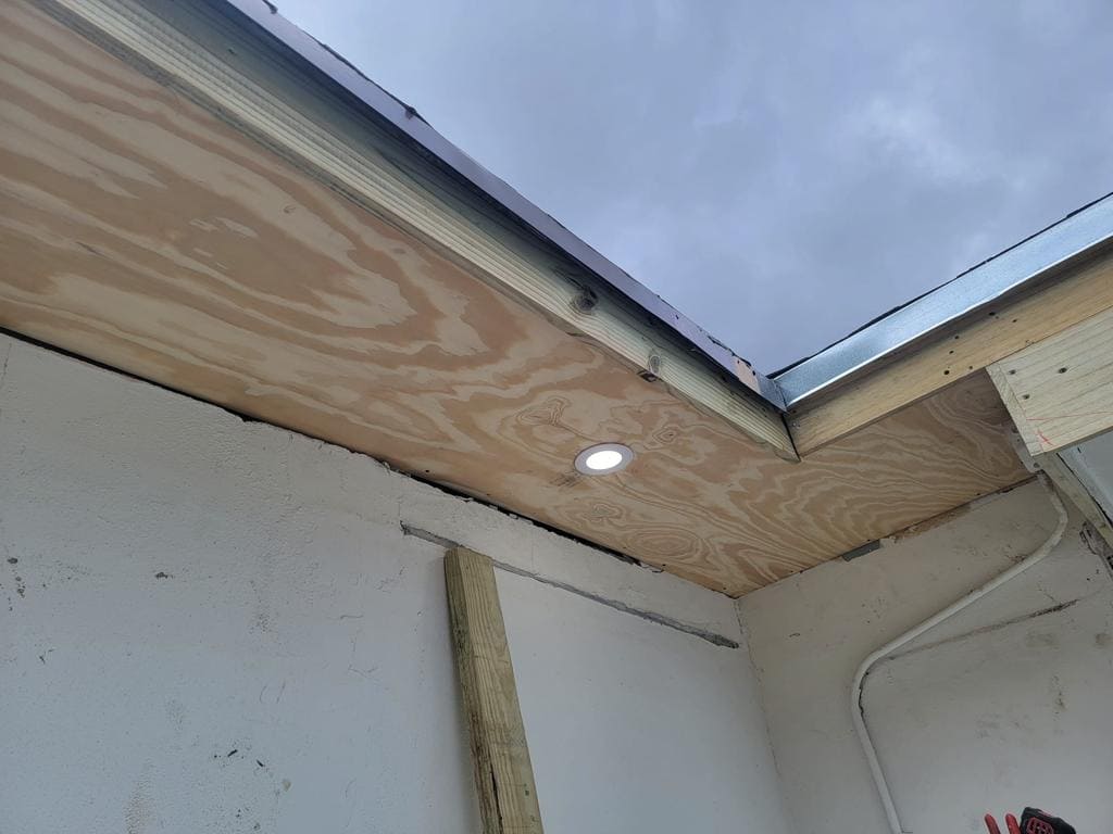 New plywood soffit with a recessed light installed during a roofline repair - Handyman Group SFL