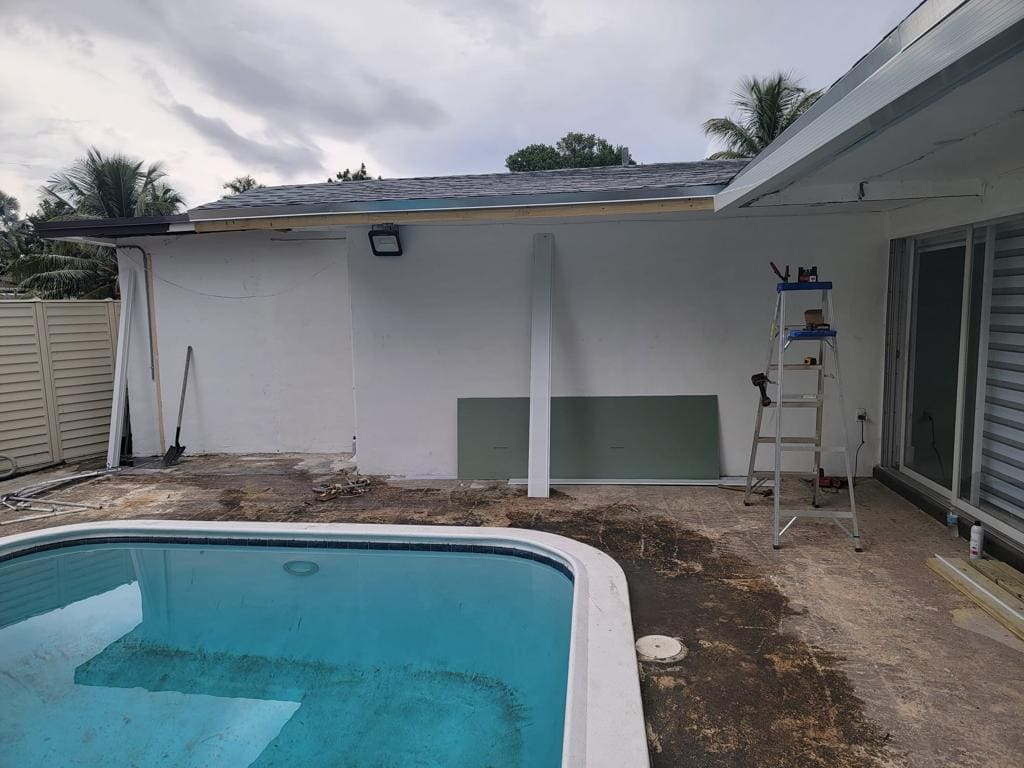 Exterior patio wall and roofline repair with drywall panels staged for installation - Handyman Group SFL