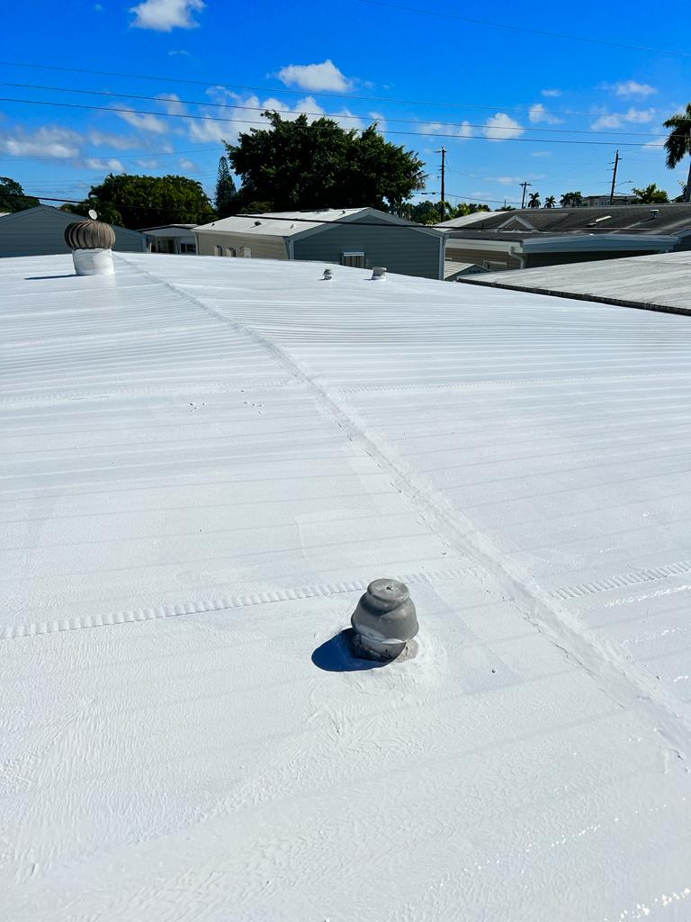 White roof coating applied around a vent boot on a flat roof - Handyman Group SFL